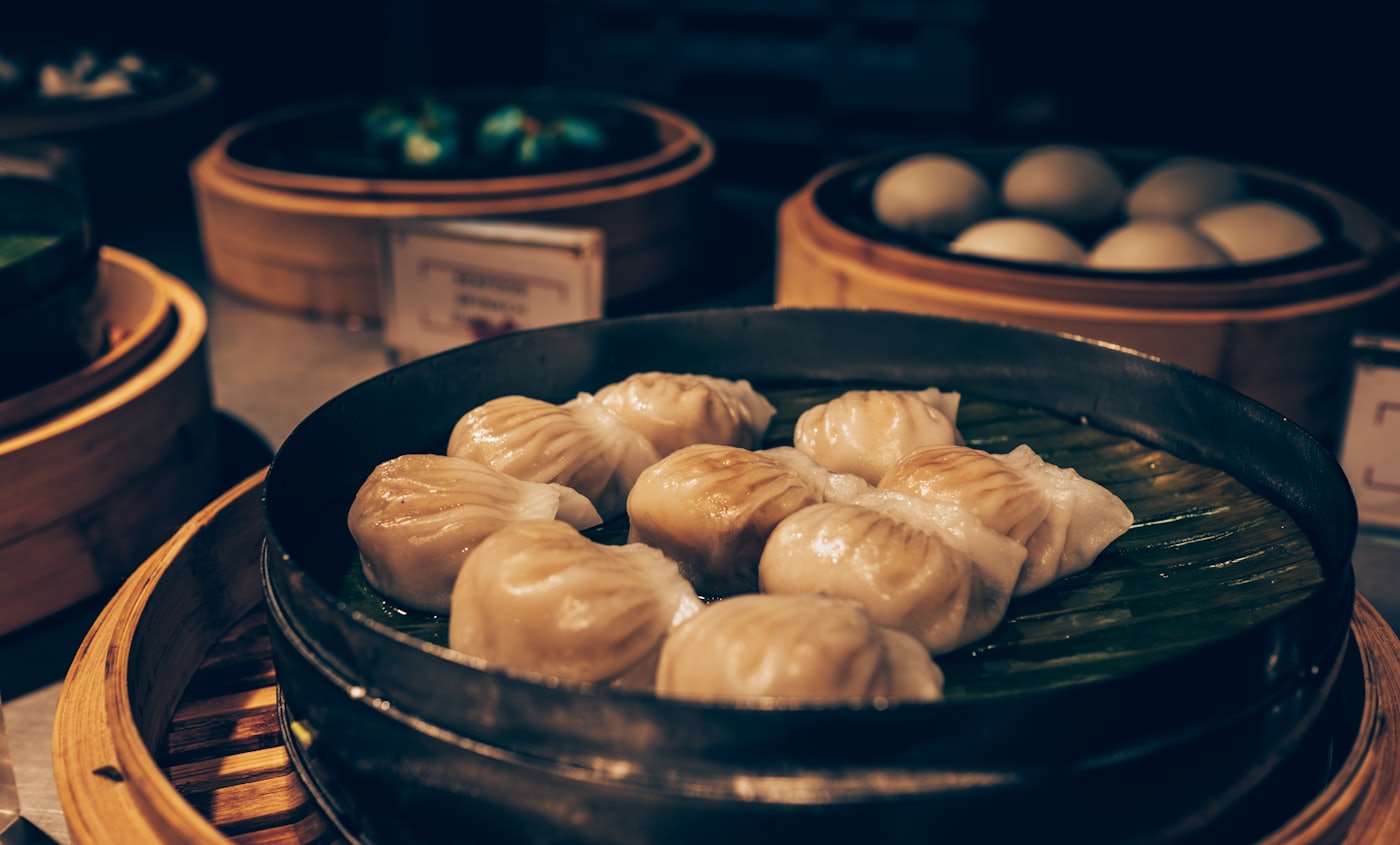 Freshly steamed bao buns in a bamboo pan