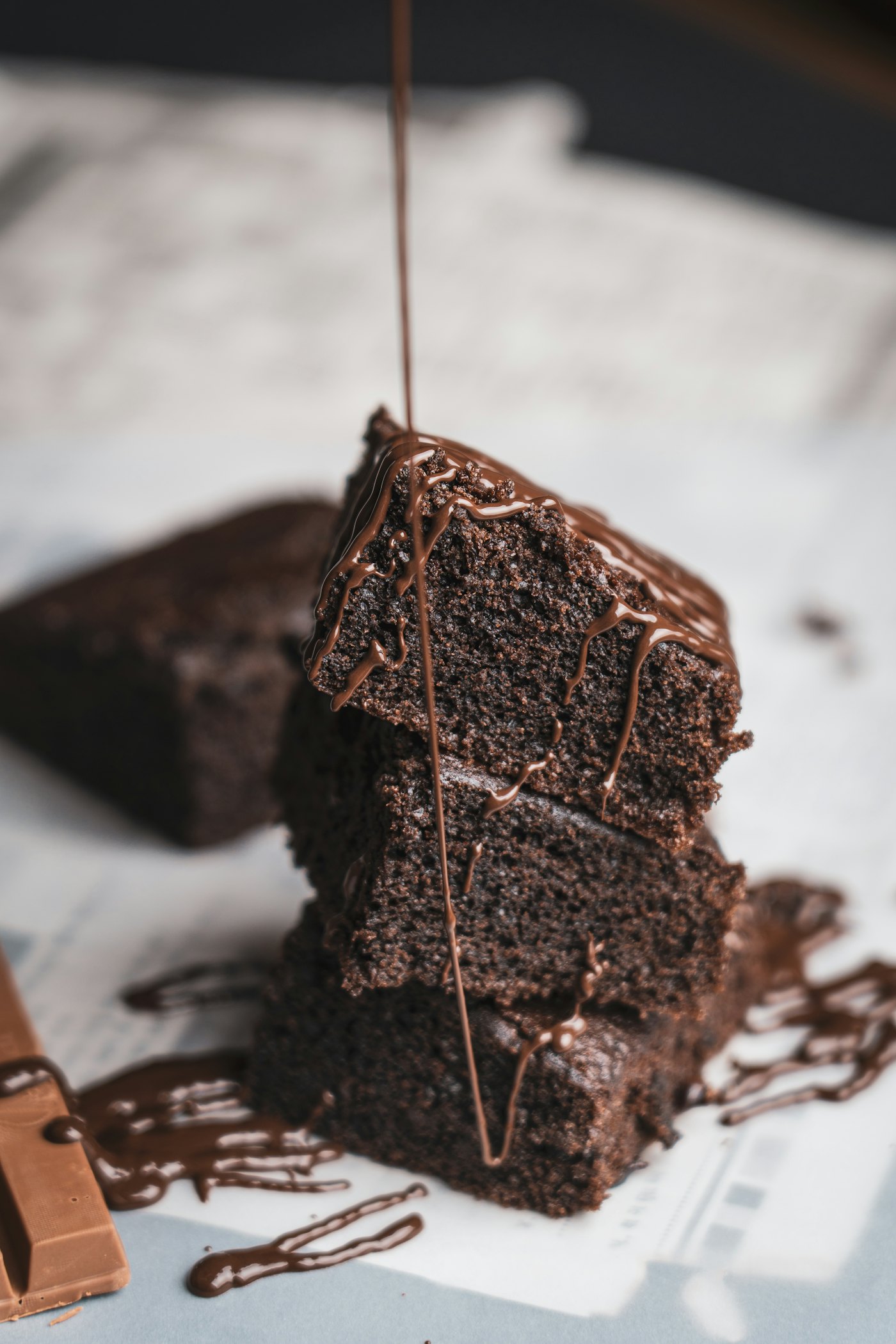 Six dense fudge brownie squares with a shiny cracked top, dusted with cocoa