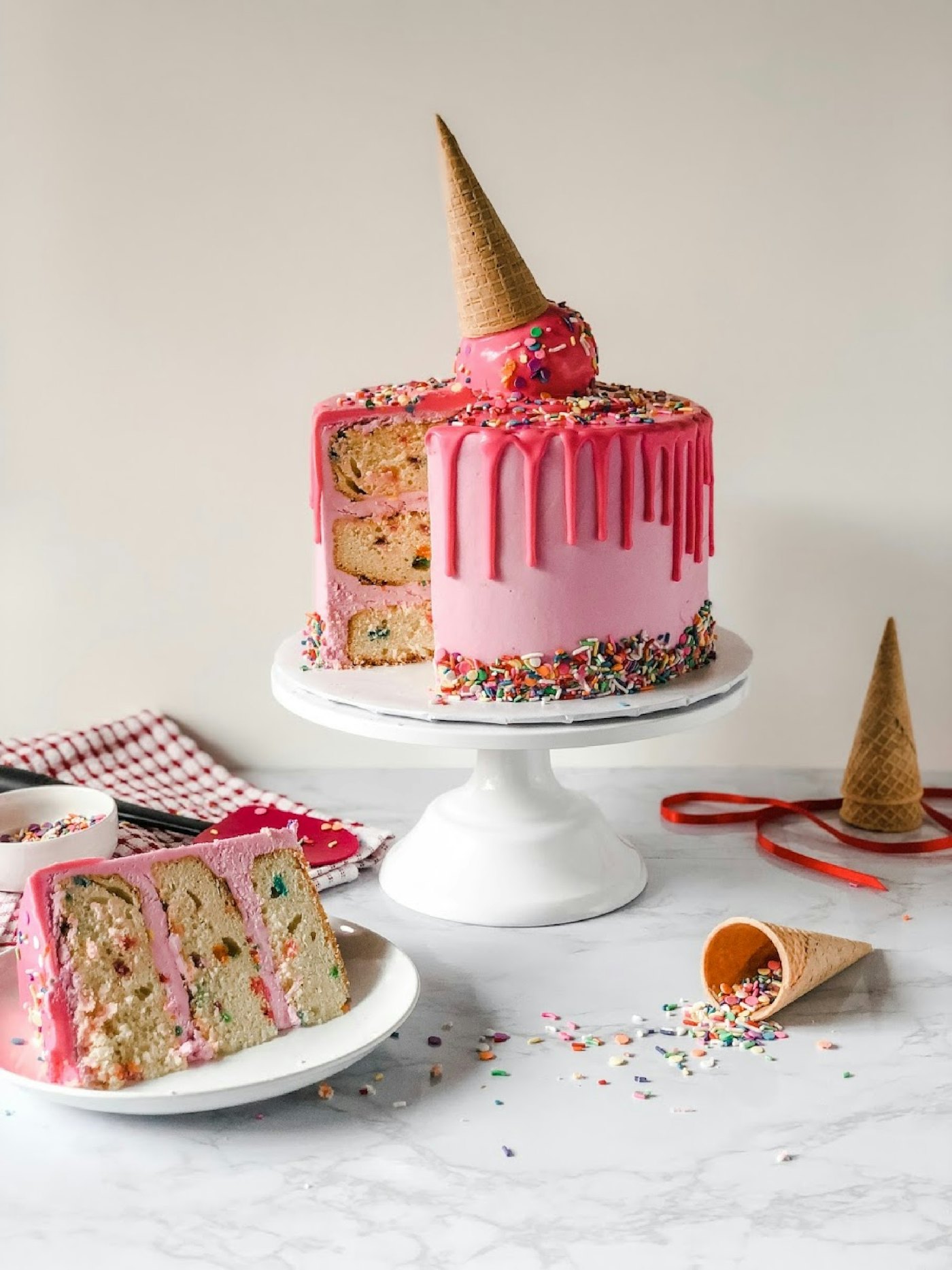 A pink drip celebration cake finished with sprinkles