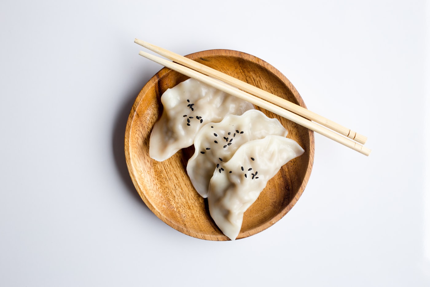 A bowl of dumplings served with chopsticks