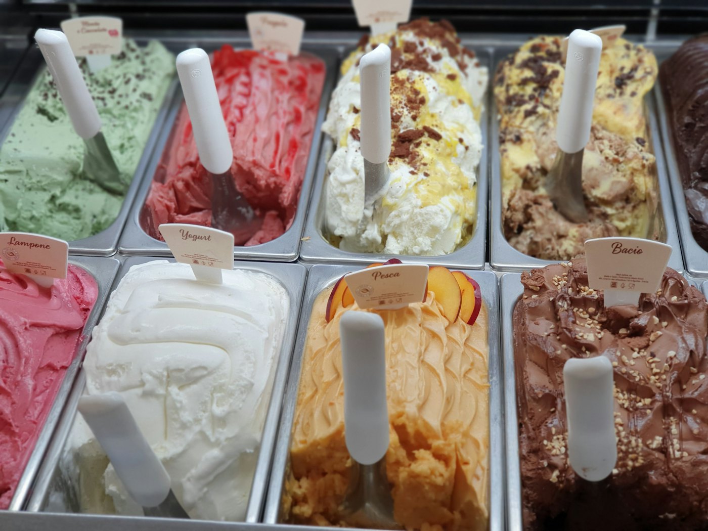 A gelato case lined with many fresh flavors