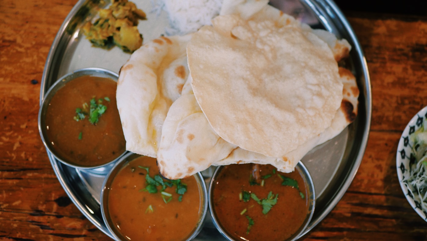 Nasi lemak with rice, curry and crisp poppadoms on a plate